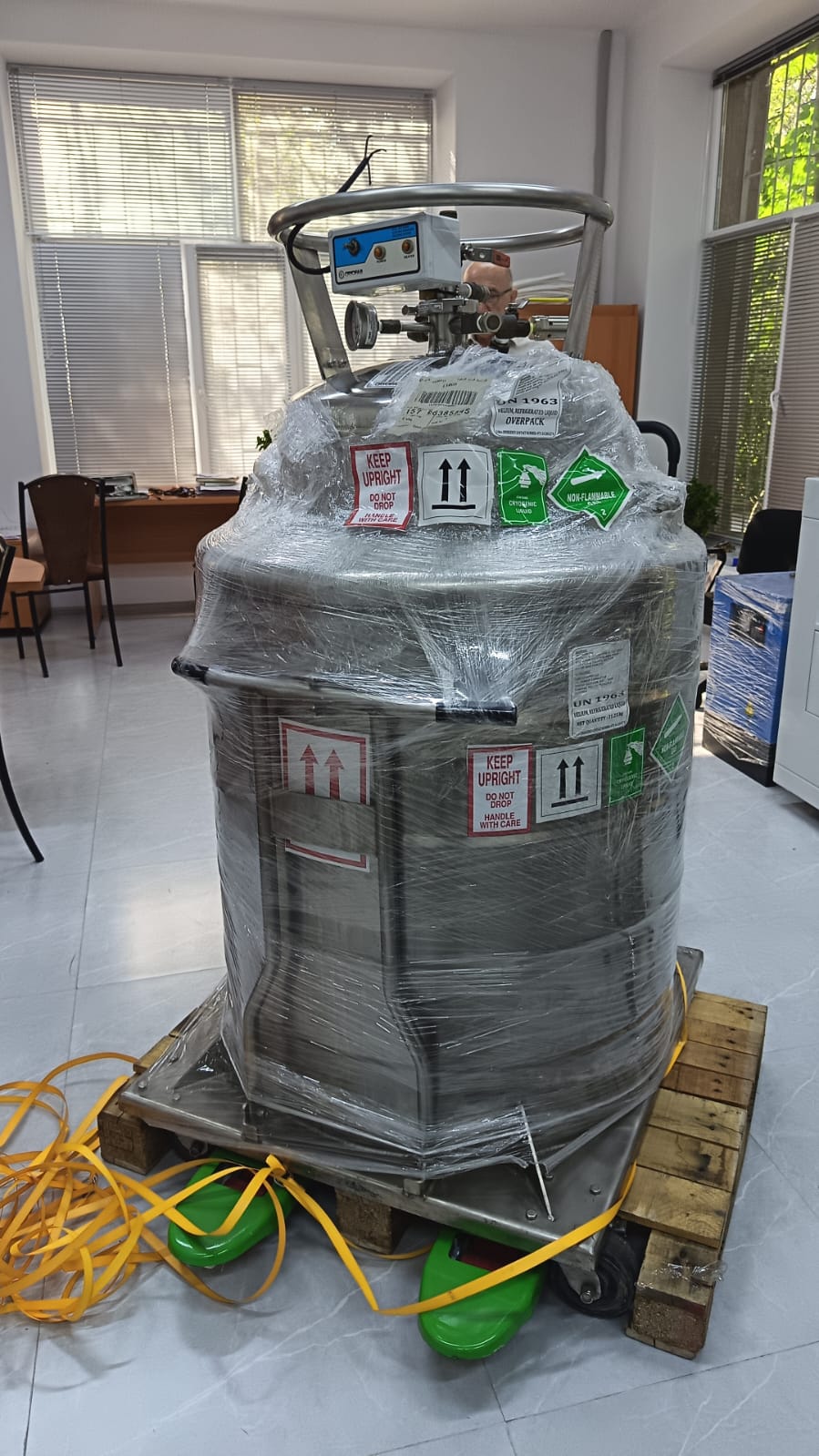 Cryogenic dewar of liquid helium on a pallet, labelled UN 1963 helium refrigerated liquid, keep upright, non-flammable gas